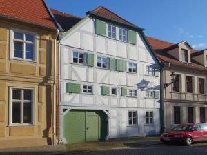 un edificio blanco y verde con garaje en Brezelhaus, en Tangermünde