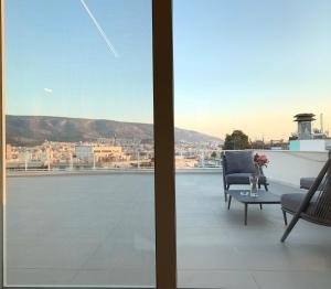 eine Vase mit Blumen auf einem Tisch auf einem Balkon in der Unterkunft Kolonaki Terrace in Athen