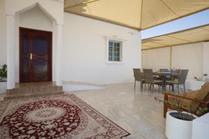 a room with a door and a table with chairs at Ras Al Hadd Orchid in Al Ḩadd
