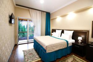 a hotel room with a bed and a window at Hotel Tauruh in Dombay