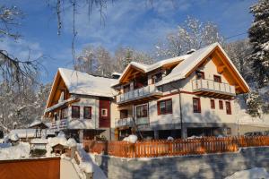 ein schneebedecktes Haus mit einem Zaun in der Unterkunft Gästehaus Bachmann in Hermagor