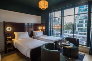 En eller flere senger på et rom på The Chow Kit - an Ormond Hotel