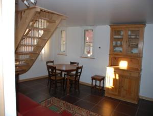 une salle à manger avec une table et un escalier dans l'établissement La Maison de Georges - Les Coquelicots, à Scharrachbergheim-Irmstett