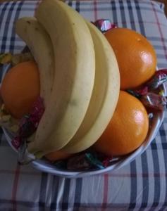 a bowl of fruit with bananas and oranges on a table at Appartamento Antonia in Venice