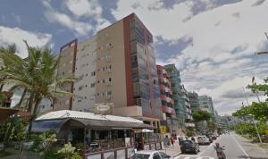 un edificio alto en una calle de la ciudad con coches en Ultimo Andar, Frente ao Mar Itapema SC, en Itapema