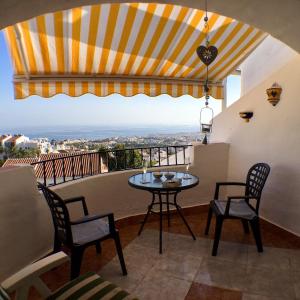 a balcony with a table and chairs and a view at Apartment with Panoramic Views, San Juan de Capistrano, Nerja in Nerja