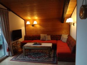 a living room with a red couch and a table at Haus Christine Aigen Schlägl - Moldau in Aigen im Mühlkreis