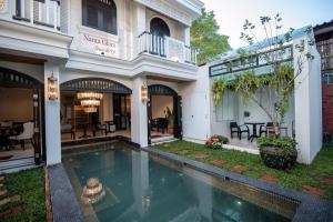a house with a swimming pool in front of it at Nanta Glam CM Hotel & Residences in Chiang Mai