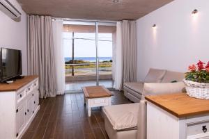 a living room with a couch and a tv at The Beach in La Paloma