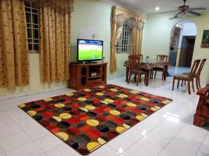 ein Wohnzimmer mit einem TV und einem Teppich in der Unterkunft Muslim Homestay Ustaz 2 in Taiping