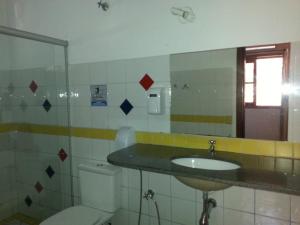La salle de bains est pourvue d'un lavabo, de toilettes et d'un miroir. dans l'établissement Pousada do Irlandês, à Pirenópolis