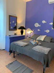 een slaapkamer met een bed met een paarse muur bij Violetta Portofino by PortofinoVacanze in Rapallo