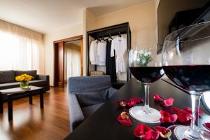 
a living room filled with furniture and a wine glass at Astoria Palace Hotel in Palermo
