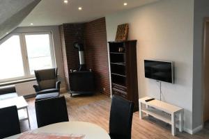 a living room with a television and a stove at Ferienwohnung Schwalbennest in Hanerau-Hademarschen