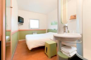 a small bathroom with a bed and a toilet at ibis budget Brugge Centrum Station in Bruges