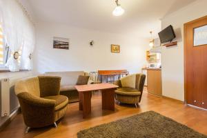 a living room with a couch and chairs and a table at Ośrodek Wypoczynkowy Cypel in Polańczyk