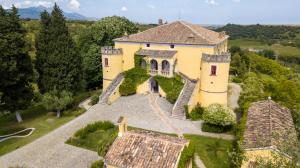 an aerial view of a large yellow house at Castello di Serragiumenta in Firmo