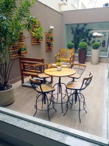 um pátio com uma mesa, cadeiras e plantas em Mirante Flat em Ouro Branco