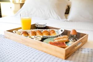 a tray of pastries and an orange juice on a bed at Petra Boutique Homes in Aryinónda