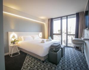 a hotel room with a bed and a large window at Le Magic H&ocirc;tel & Spa in Vitr&eacute;