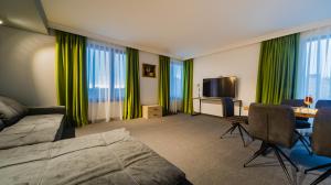 a hotel room with a bed and a table and a television at A&M Hotel with free parking in Plovdiv
