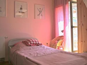 a bedroom with a bed with pink walls and a window at Brezelhaus in Tangermünde