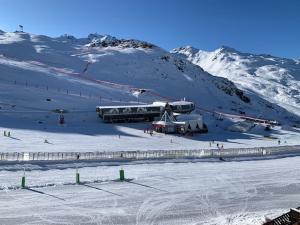 una estación de esquí en una montaña nevada con una pista de esquí en Temple du Soleil, en Val Thorens