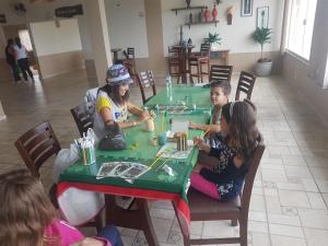 un groupe d'enfants assis à une table jouant à un jeu dans l'établissement Molise Hotel Fazenda, à Serra Negra