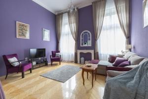 a living room with purple walls and a couch at Eclectic Luxury & Spacious 2BR AC Apt in Center in Budapest