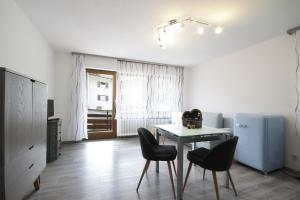 La cuisine est équipée d'une table, de chaises et d'un réfrigérateur. dans l'établissement Apartment Mühlbach, à Nesselwang