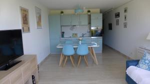 a kitchen with a table and two blue chairs at Les Trois Oliviers à Cassis in Cassis