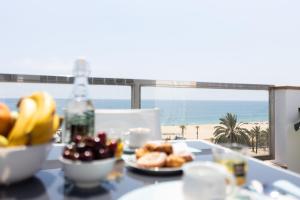 - une table avec une assiette de nourriture et une vue sur la plage dans l'établissement matarolux17, à Mataró