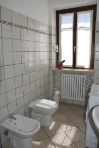 un bagno bianco con un water e un lavandino di Casa dei Ciliegi Castell'Alfero a CastellʼAlfero