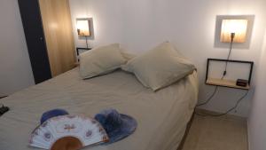 a bedroom with a bed with a hat on it at Les Trois Oliviers à Cassis in Cassis