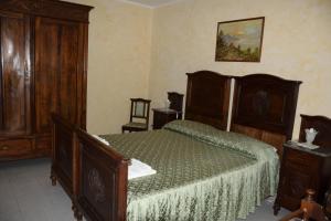 um quarto com uma cama grande e mobiliário em madeira em Casa dei Ciliegi Castell'Alfero em CastellʼAlfero