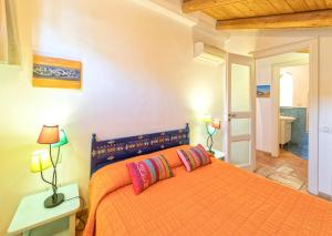 una camera con letto arancione e 2 cuscini di Villa Lieta a Ischia