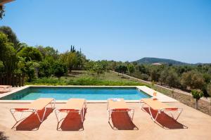 - une piscine avec 2 chaises et une table dans l'établissement Finca Pessal, à Caʼs Concos