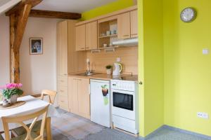 a kitchen with a table and a clock on the wall at Apartmany A.Ša Kašperské Hory in Kašperské Hory