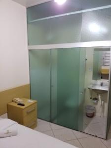 a glass shower in a bathroom with a sink at Hotel Pilar de Minas in Ouro Branco