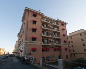 a tall building with red balconies on a street at Hotel Tirreno in Genoa