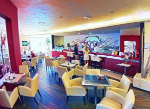 a restaurant with tables and chairs and a bar at Grand Hotel Park in Dubrovnik