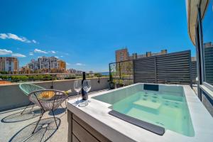 bañera de hidromasaje en el balcón con vistas a la ciudad en Priska Med Luxury Rooms en Split