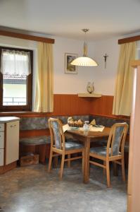 een eetkamer met een houten tafel en stoelen bij Ferienwohnung Pezzei in Schlitters