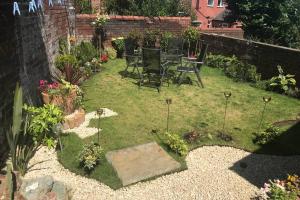 a garden with a table and chairs in it at Soofi House in Sheffield