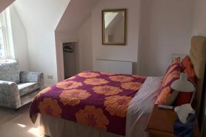 a bedroom with a bed and a chair and a mirror at Soofi House in Sheffield