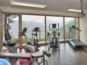 a gym with several exercise bikes in front of a large window at Hotel Gnollhof in Chiusa