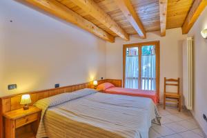 a bedroom with a large bed and a window at Apartments La Gran Becca in Antey-Saint-André