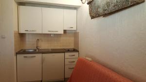 a small kitchen with white cabinets and a sink at Apartment La roza in Funtana +15 photos