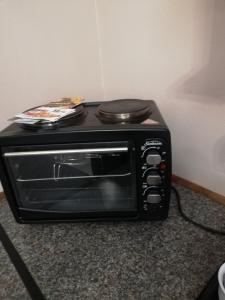 a black toaster oven sitting on top of a counter at KIHARA GUESTHOUSE in Bethlehem