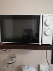 a microwave oven sitting on a shelf at KIHARA GUESTHOUSE in Bethlehem